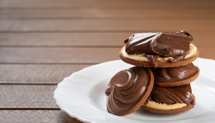 Chocolate sweet melting nougat cream on cookies on a white plate with copy space, horizontal, closeup, selective focus