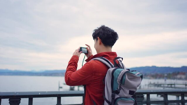 Asian backpacker use camera taking a picture of beautiful landscape.