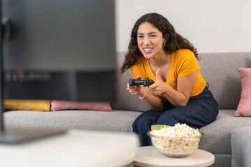 Young woman using the controller playing video games © Guillermo Spelucin