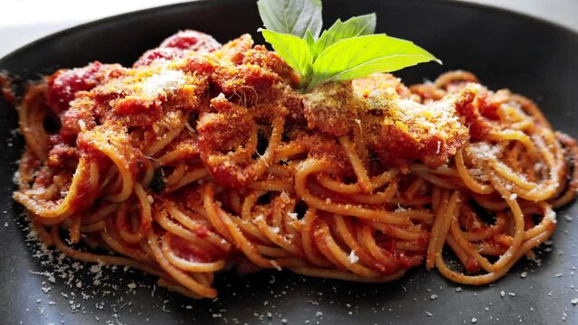 Italian spaghetti with tomatoe and basilic in a restaurant close up
