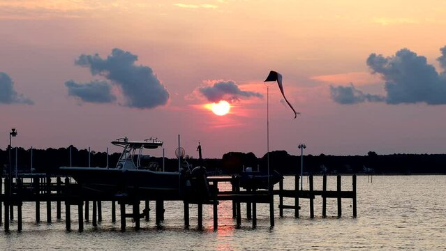 Piney Point, Maryland, USA A sunrise through the clouds over the mouth of the Potomac River on a pier on the Chesapeake Bay.