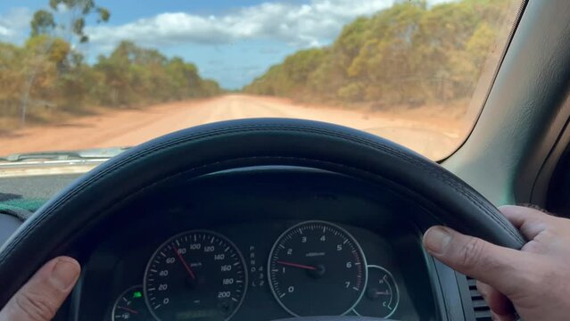 POV (point of view of a person) driver holding steering wheel while driving an off road car land vehicle on a long off road in Cape York peninsula in tropical far north of Queensland, Australia.