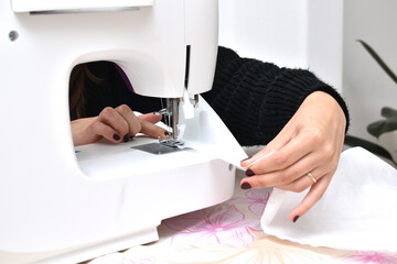 Naklejka premium woman using a sewing machine sewing fabrics
