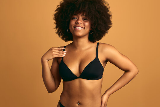 Smiling black woman with curly hair in underwear