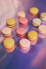 French cake macaron. Set of cute sweets on colorful rainbow background. almond cookies, pastel colors, top view