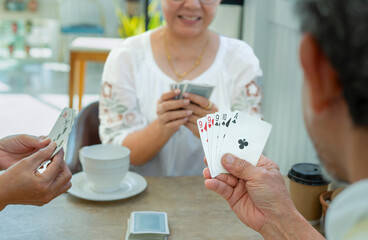 group of old pensioners playing cards at home,concept of senior freetime, recreation,entertainment,playing cards game is one of the activities that encourages social interaction,help memory retention