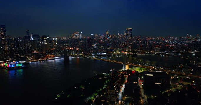 Lightening sparkles in the sky above beautiful New York. Night metropolis panorama from aerial view.
