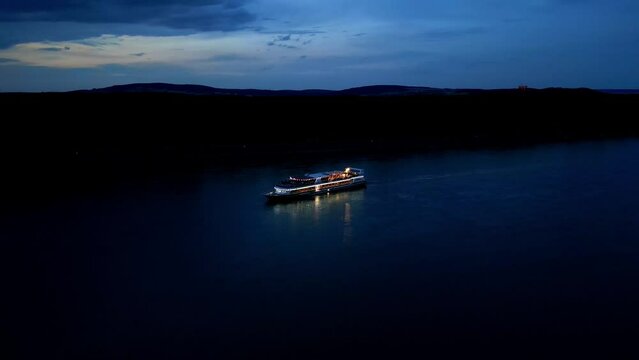 Aerial View Of Ship Cruising Danube River At Night - drone shot