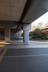 Concrete structure and asphalt road space under the overpass in the city - 630189408