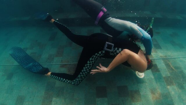 Freedivers train in the pool and practice pool rescue. Group of freedivers work out in the pool