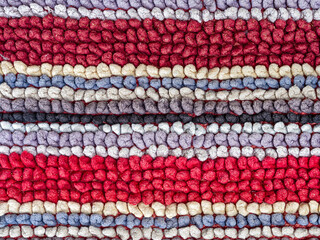 Detail of the linear patterns in a colorful woven fabric rug