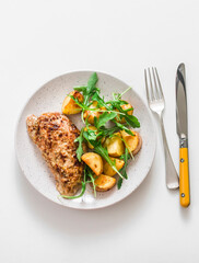 Mustard, greek yogurt marinade baked turkey  and new potatoes, arugula salad on a light background,...