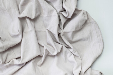 Fabric backdrop. Gray crumpled natural cotton fabric on light background. Natural linen background....