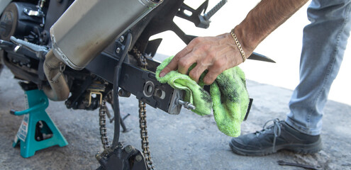 Biker man cleaning motorcycle. Maintenance, repair motorcycle