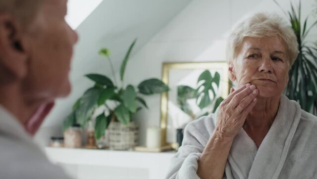 Senior caucasian woman in the bathroom having a strong toothache Shot with RED helium camera in 8K.