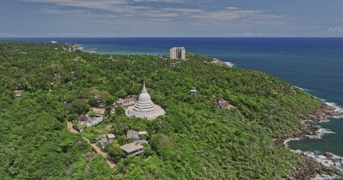 Unawatuna Sri Lanka Aerial v9 cinematic drone flyover lush green jungle capturing hillside Japanese Peace Pagoda Rumassala Temple and coastal ocean view in summer - Shot with Mavic 3 Cine - April 2023