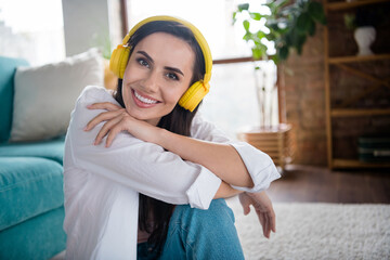 Photo of positive cheerful lady listen songs using modern technology headphones in sunlight flat apartment