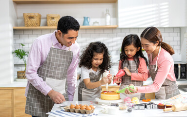 Portrait of enjoy happy love asian family father and mother with little asian girl daughter child play and having fun cooking food together with baking cookie and cake ingredient in kitchen