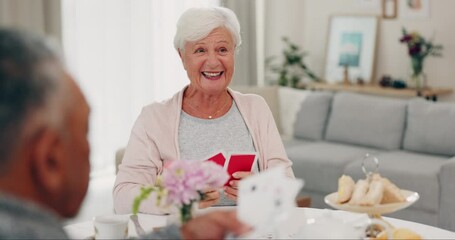 Playing cards, retirement and senior friends at a tea party together during a visit in a home for bonding. Poker cards, community and games with a group of elderly people at a social gathering