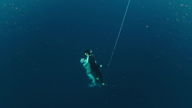 Freedivers work out on the rope and practice rescue. Woman free diver delivers her buddy from depth to the surface after blackout