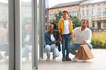 Family shopping. Happy parents and son with purchases near mall outdoors