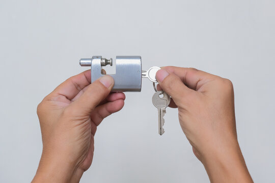 Close-up shot of hands holding metal padlock and keys