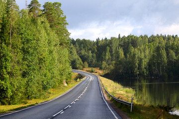 Country road with lake and forest, beautiful landscape