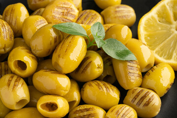 Grilled green olives on black background