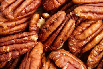 Pecan nuts kernel texture background closeup. Heap of peeled pecan halves. Peeled pecan nuts expose their tender core