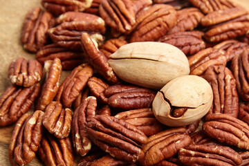 Pecan nuts texture background closeup. Heap of pecan halves. Peeled pecan nuts on wooden background, top view