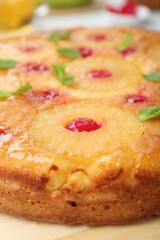 Tasty pineapple cake with cherries and mint on table, closeup