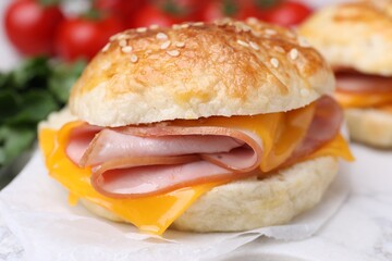 Delicious bagel with ham and cheese on table, closeup