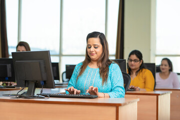 Indian woman working on computer at office.