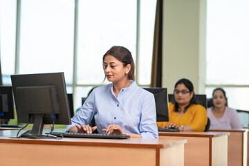 Indian woman working on computer at office.