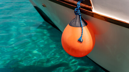 Orange float on the side of a boat - obrazy, fototapety, plakaty