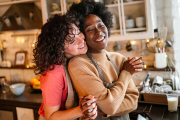 Authentic shot of happy married homosexual female gay couple laughing and embracing, lgbtq concept.