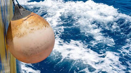 A faded orange float on the side of a boat