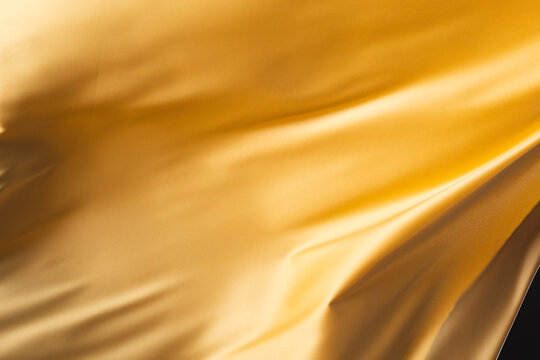 Fototapeta Close up of gold shiny silk fabric with copy space