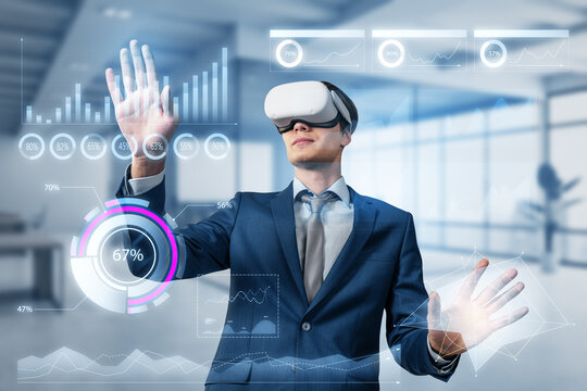 Attractive young european business man with VR glasses using glowing business chart hologram on blurry office interior background. Virtual reality, finance and metaverse concept. Double exposure.