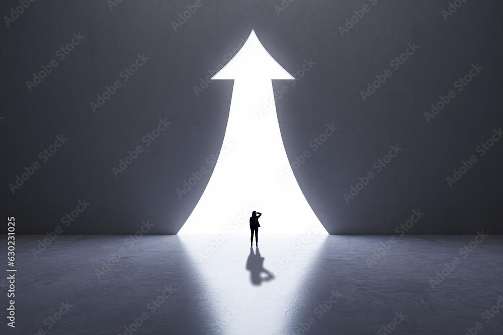 Wall mural back view of business woman silhouette in abstract concrete interior with upward arrow opening. succ