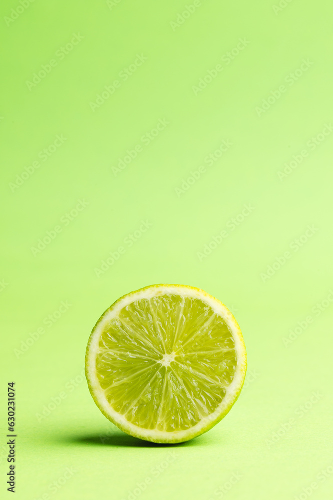 Poster close up of halved lime and copy space on green background