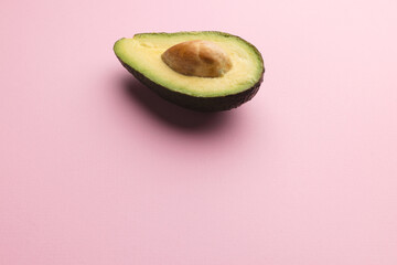 Close up of half of avocado and copy space on pink background © vectorfusionart