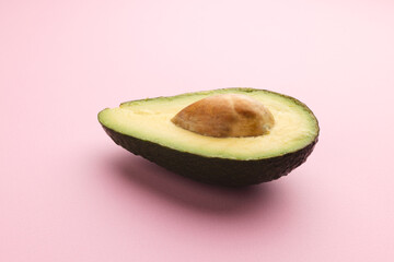 Close up of half of avocado and copy space on pink background © vectorfusionart