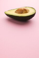 Close up of half of avocado and copy space on pink background © vectorfusionart