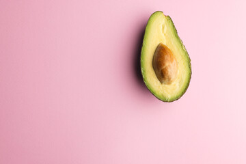 Close up of half of avocado and copy space on pink background © vectorfusionart