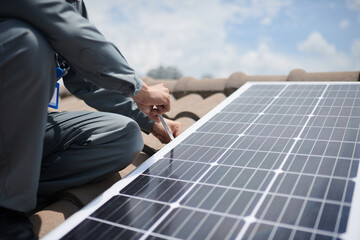 Closeup image of builder installing solar panel on roof