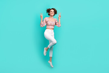 Fototapeta na wymiar Full length portrait of carefree cheerful person jumping hands fingers demonstrate v-sign empty space isolated on turquoise color background