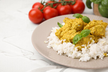 Delicious rice and chicken with curry sauce on white textured table, closeup. Space for text