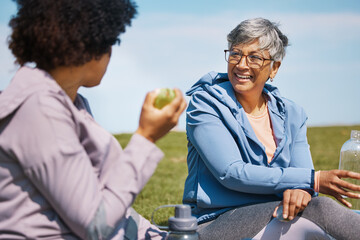 Talking, exercise and senior women friends on the grass outdoor taking a break from their workout routine. Fitness, training and healthy eating with elderly people chatting on a field for wellness