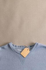 Close up of blue t shirt with tag and copy space on brown background